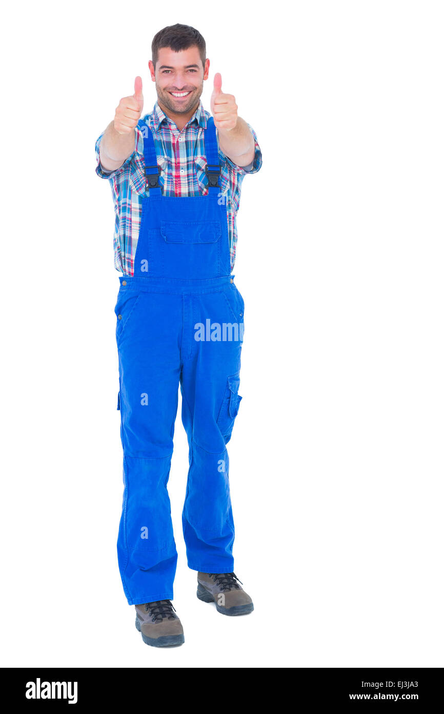 Happy handyman in coveralls gesturing thumbs up Stock Photo