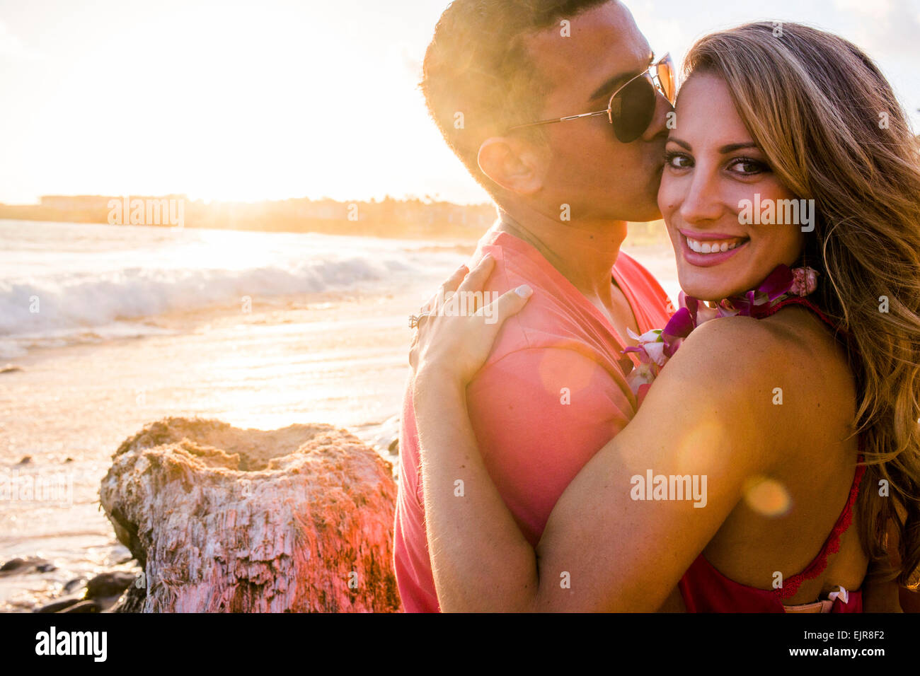 Man kissing girlfriend on beach Stock Photo