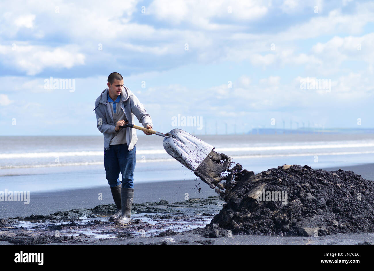 Man collecting sea-coal on Seaton Carew beach near Hartlepool, UK Stock Photo