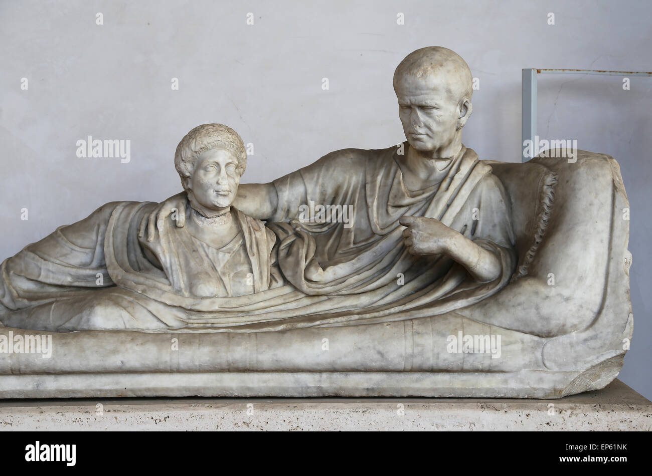 Kline funerary monument, on which the deceased is lying, wearing a toga and holding a bust of a dead woman. Marble. 1st century Stock Photo