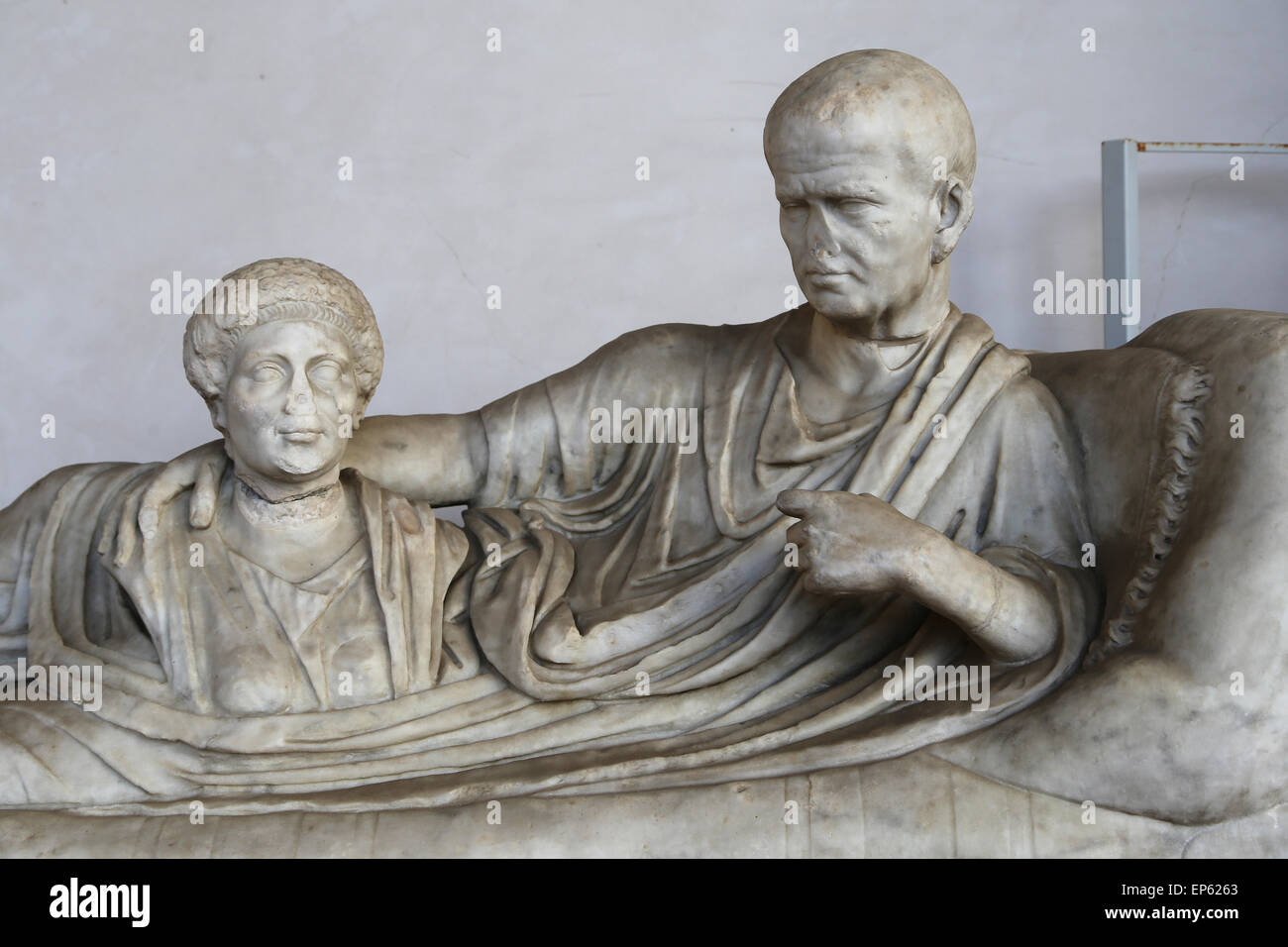 Kline funerary monument, on which the deceased is lying, wearing a toga and holding a bust of a dead woman. Marble. 1st century Stock Photo