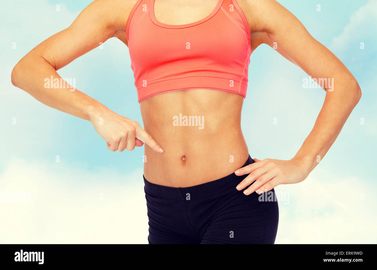 close up of woman pointing finger at her six pack Stock Photo