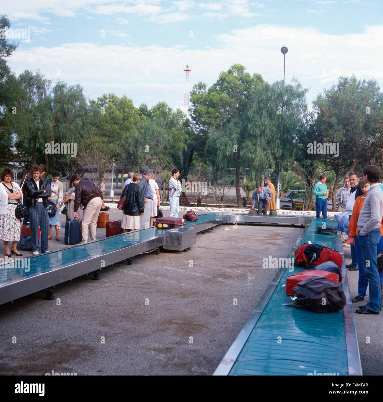 Touristen warten auf ihr Gepäck am Flughafen Almería an der Costa de Almería, Andalusien, Spanien 1980er Jahre. Tourists waiting for their luggage at Almería Airport at the Costa de Almería, Andalusia, Spain 1980s. Stock Photo