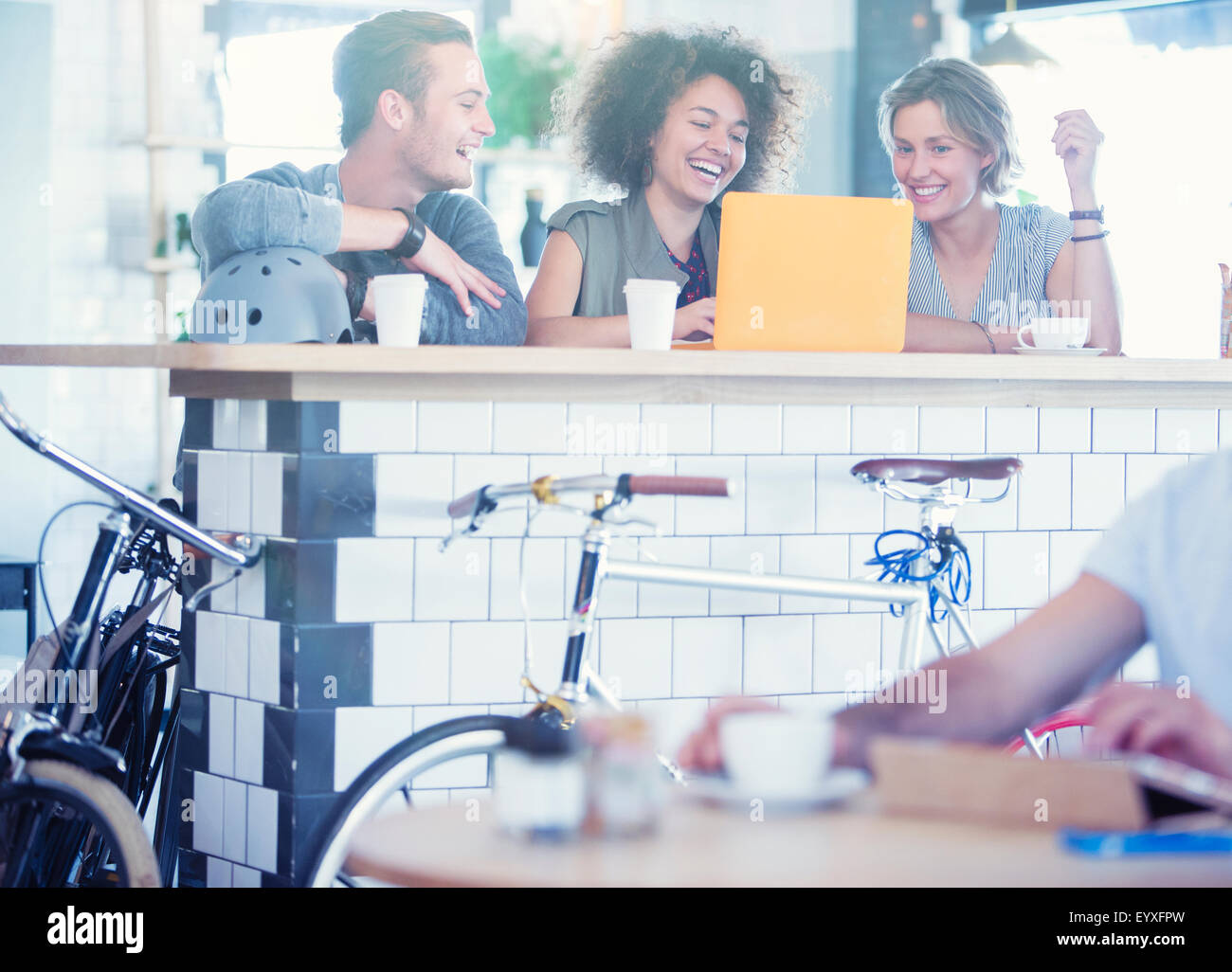 Friends sharing laptop at cafe bar Stock Photo