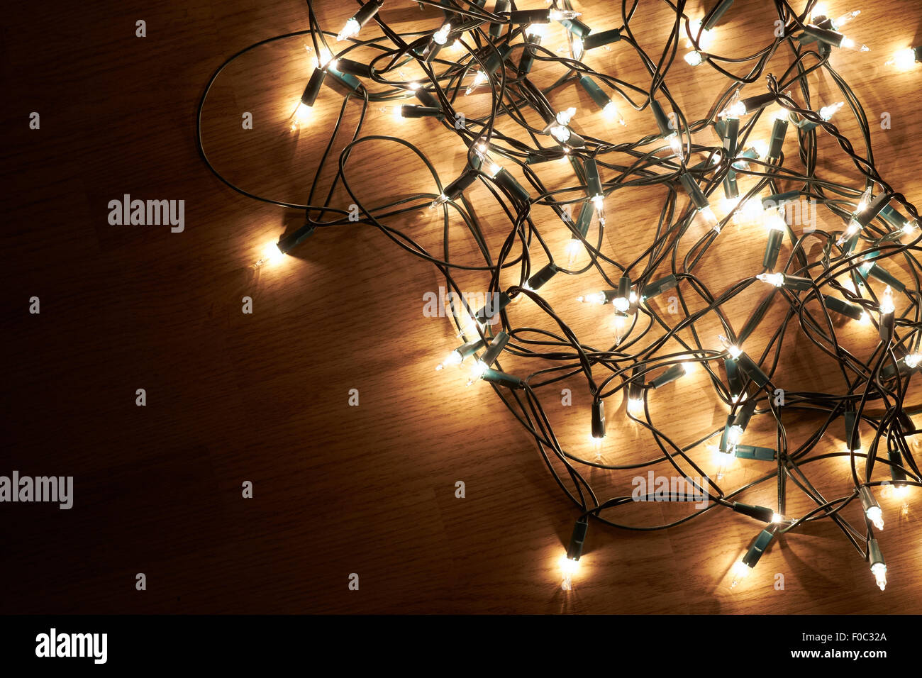 Traditional Christmas Tree lights lying on a wooden floor. Stock Photo