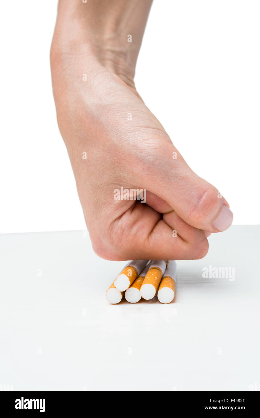 Hand squashing batch of cigarettes Stock Photo