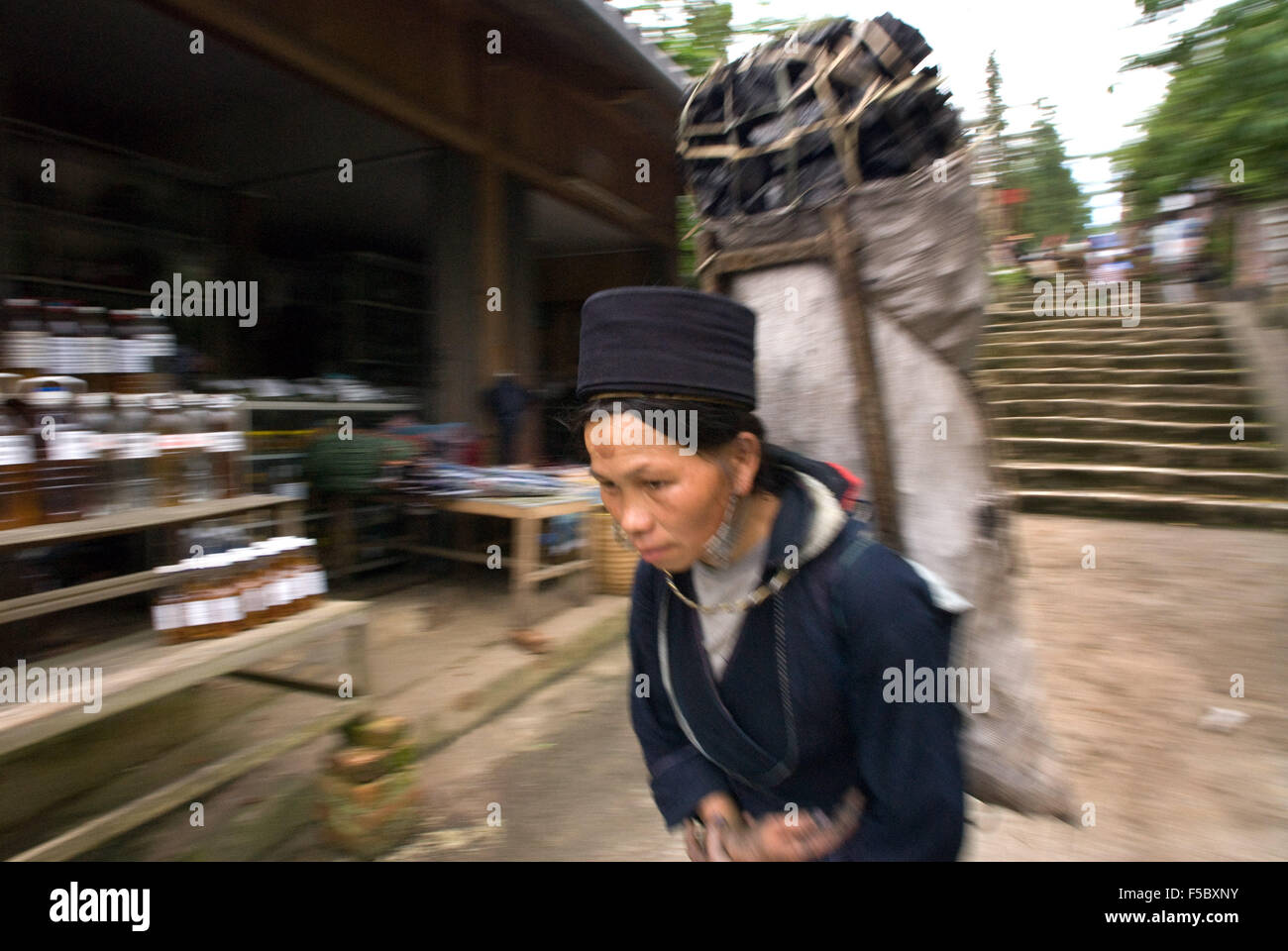 Black Hmong woman charged with coal in Sapa Vietnam. Lao Cai Province, Northern Vietnam Stock Photo