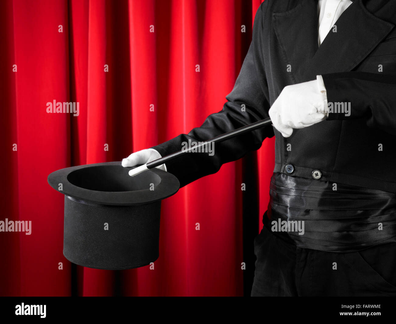 Hands of the magician with magic wand and top hat. Stock Photo