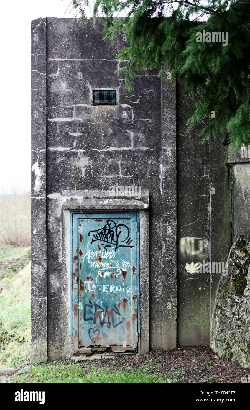 It's a photo of an abandoned Construction in concrete or cement. Wee see a green rusted door Stock Photo