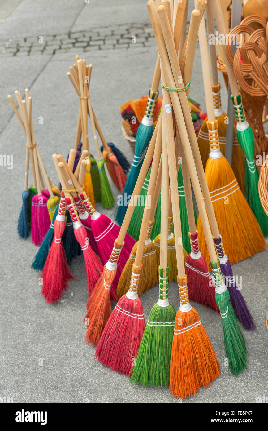 Colored brooms sells at a street market. University Square, Salzburg, Austria Stock Photo