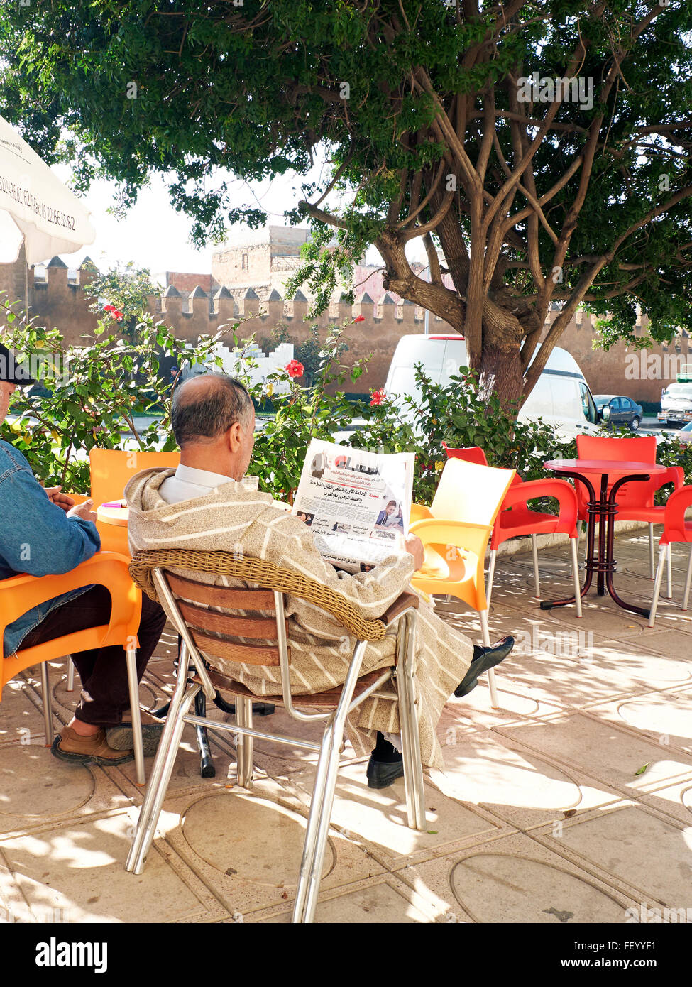 Citizen with djellaba reading the newspaper in a bar from Sale medina walls. Sale Medina, Rabat, Morocco. Stock Photo