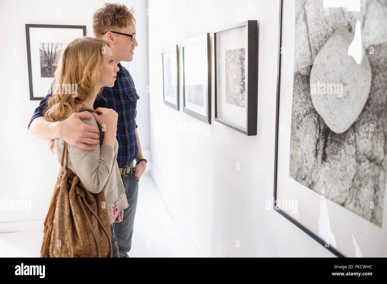 Young couple looking at photographs at museum Stock Photo