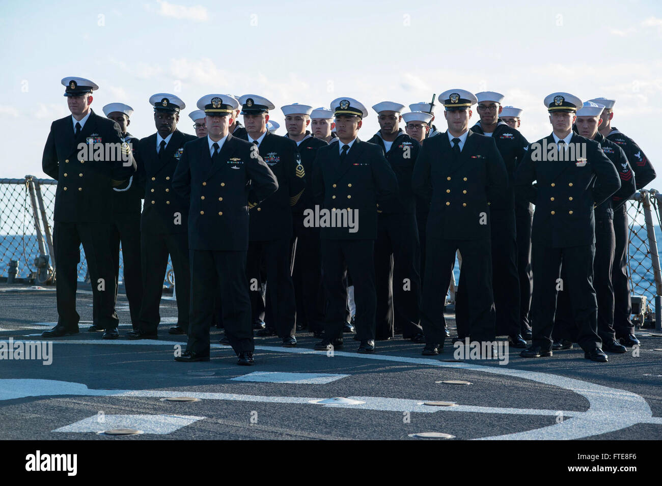 131210-N-VC236-033: MEDITERRANEAN SEA (Dec. 10, 2013) - Sailors assigned to the Arleigh Burke-class guided-missile destroyer USS Ramage (DDG 61) stand in formation at parade rest on the flight deck during a burial at sea. Ramage, homeported in Norfolk, Va., is on a scheduled deployment supporting maritime security operations and theater security cooperation efforts in the U.S. 6th Fleet area of operations. (U.S. Navy photo by Mass Communication Specialist 3rd Class Jackie Hart/Released) Stock Photo