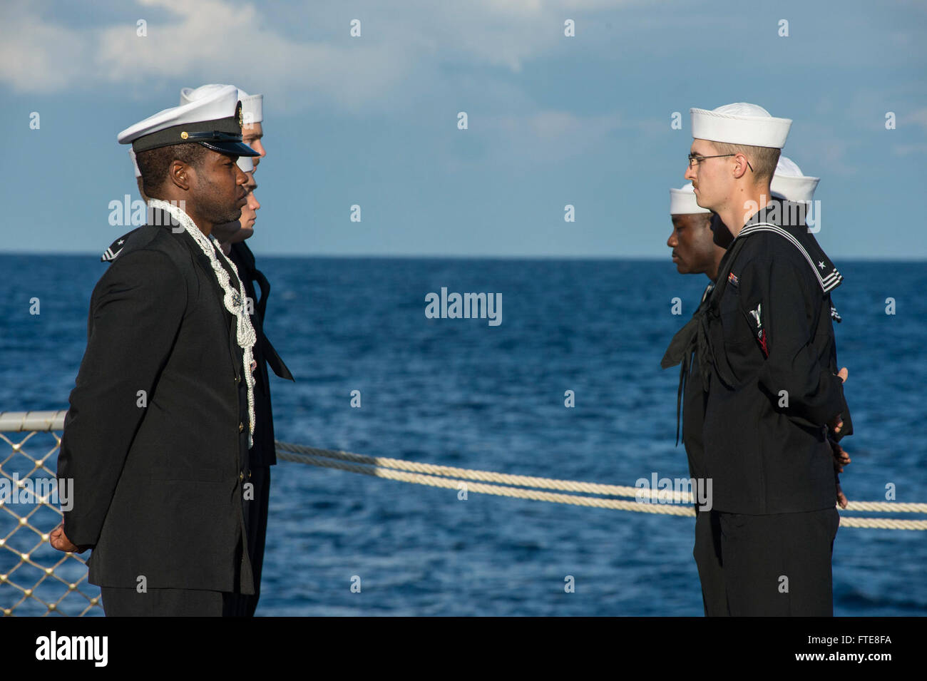 131210-N-VC236-043: MEDITERRANEAN SEA (Dec. 10, 2013) - Sailors assigned to the Arleigh Burke-class guided-missile destroyer USS Ramage (DDG 61) stand at parade rest on the flight deck during a burial at sea. Ramage, homeported in Norfolk, Va., is on a scheduled deployment supporting maritime security operations and theater security cooperation efforts in the U.S. 6th Fleet area of operations. (U.S. Navy photo by Mass Communication Specialist 3rd Class Jackie Hart/Released) Stock Photo