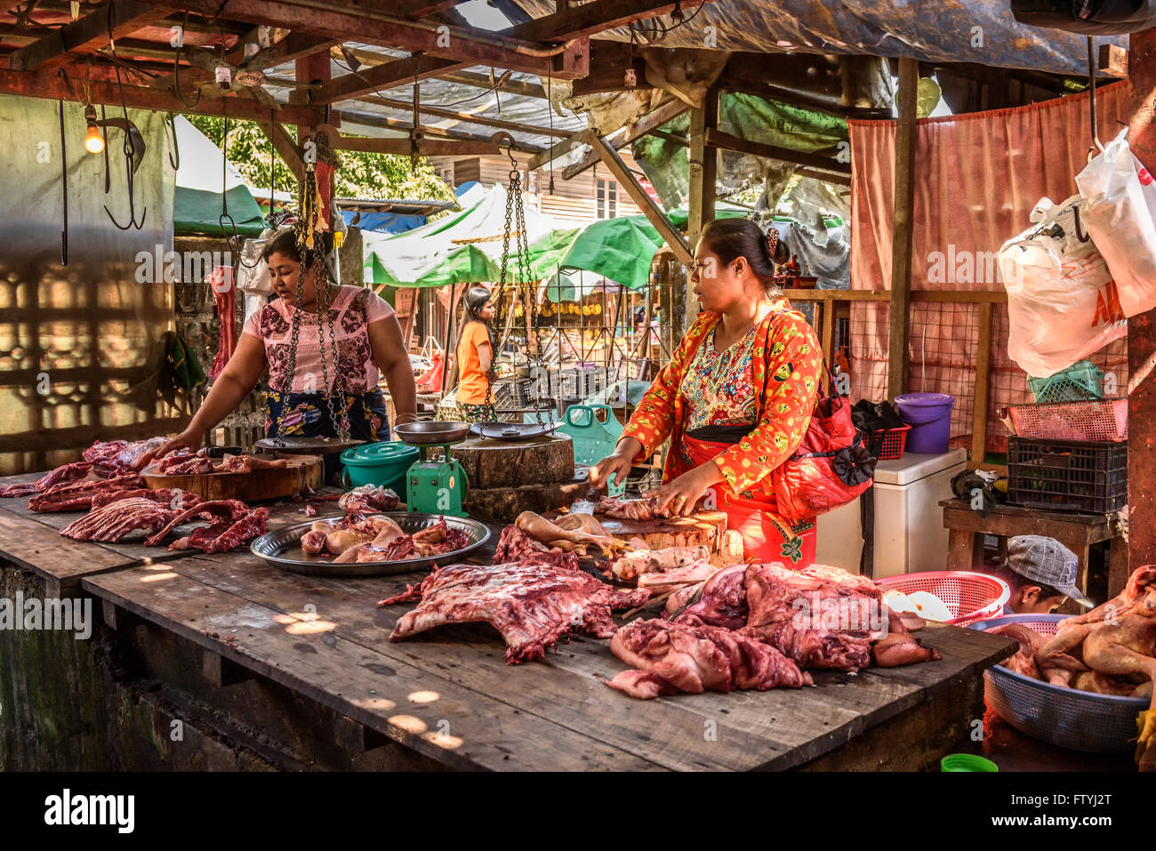 Asian woman butcher sells meat at a local market in Yangon Stock Photo