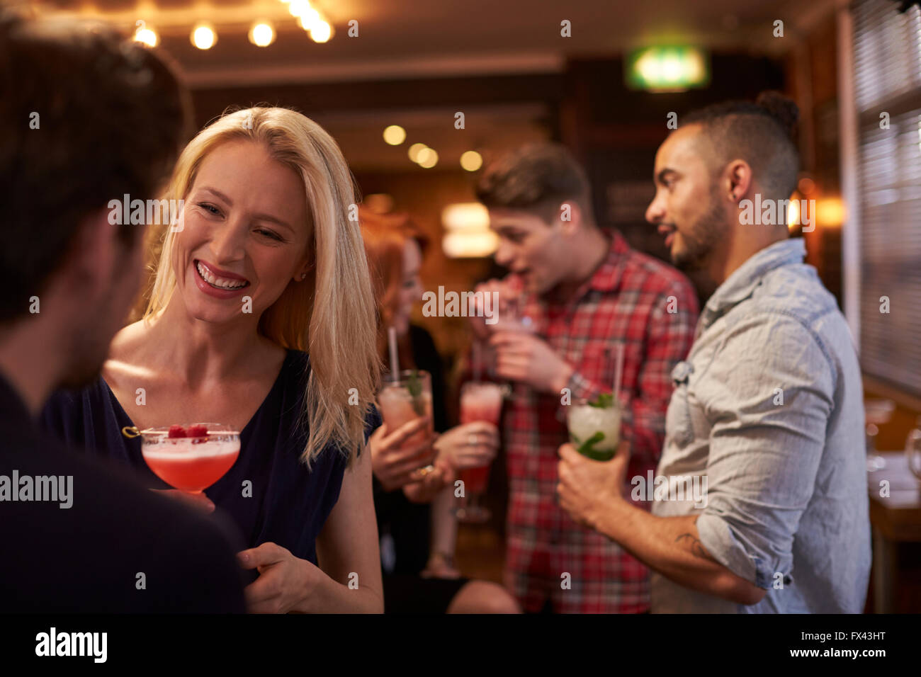 Group Of Friends Meeting For Evening Drinks In Cocktail Bar Stock Photo