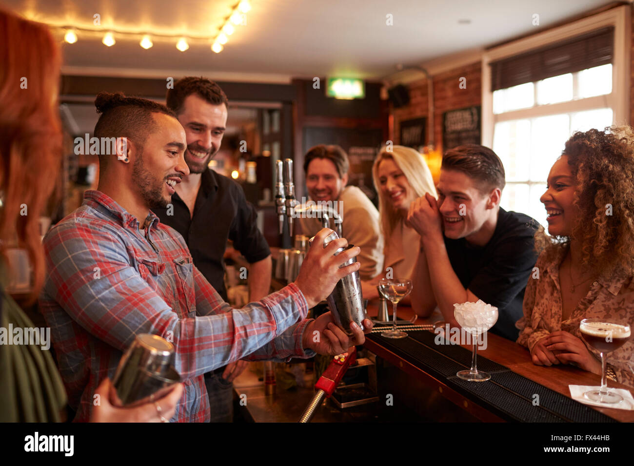 Man Learning How To Mix Cocktail At Lesson In Bar Stock Photo