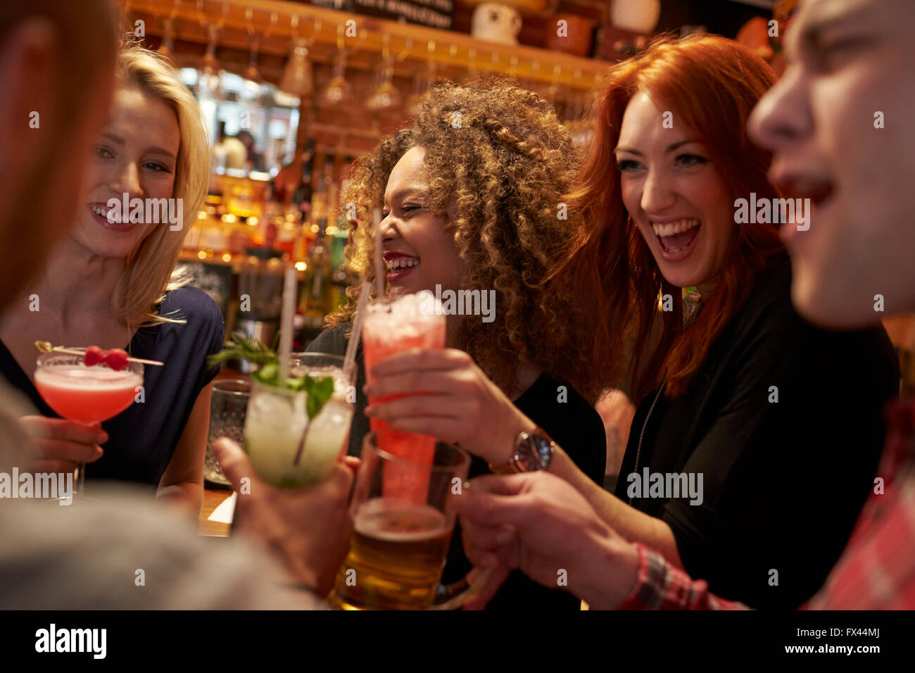 Group Of Friends Meeting For Evening Drinks In Cocktail Bar Stock Photo