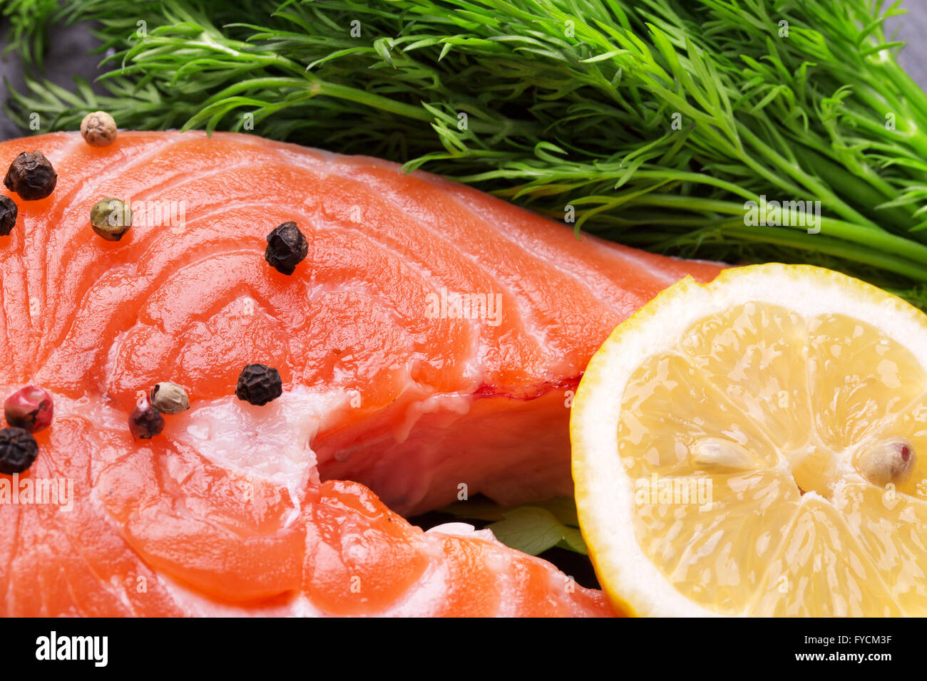 red fish steak with spices and vegetables on a slate table. Stock Photo