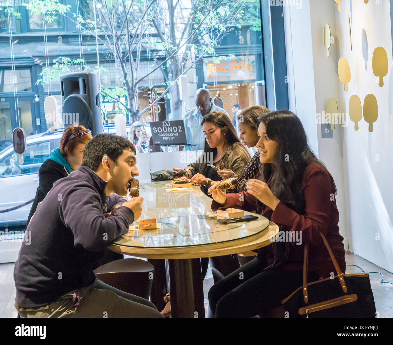 Customers line up for their bespoke Magnum ice cream bar studded with toppings at the Magnum pop-up dipping bar in Soho in New York on Saturday, April 23, 2016. Workers for Magnum, a brand of the Good Humor company, dip your bar in up to three ingredients including everything from Himalayan sea salt to the more plebeian nuts. The pop-up is open through August 7. (© Richard B. Levine) Stock Photo