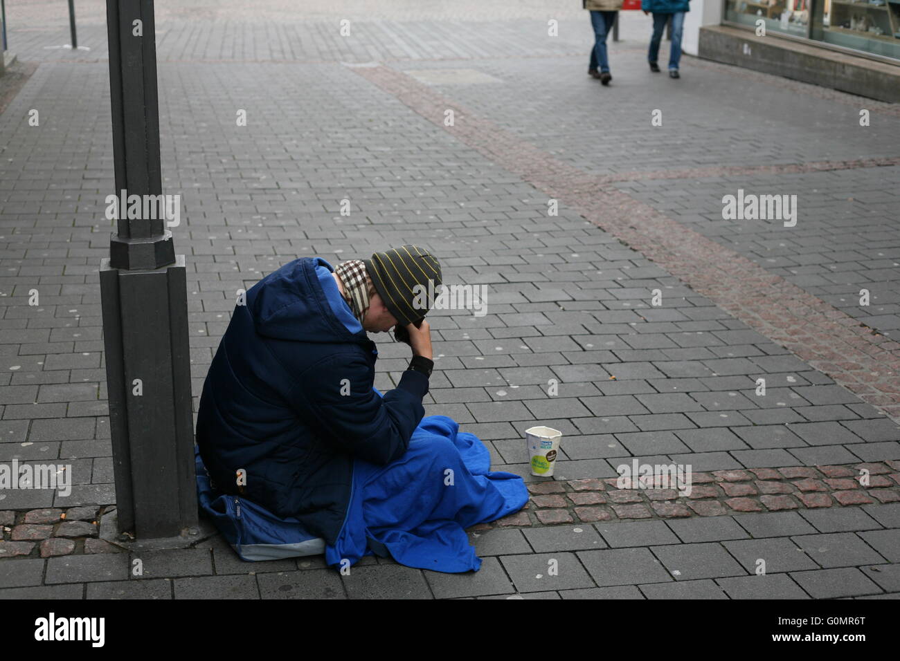 poor man sitting on the street in Bonn, Germany Stock Photo