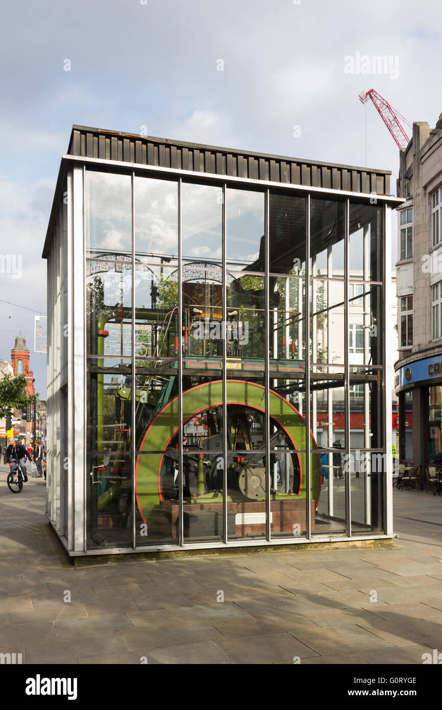 A Corliss stationary steam engine, made by Bolton firm Hick Hargreaves, displayed in a large glass case on Oxford Street, Bolton Stock Photo