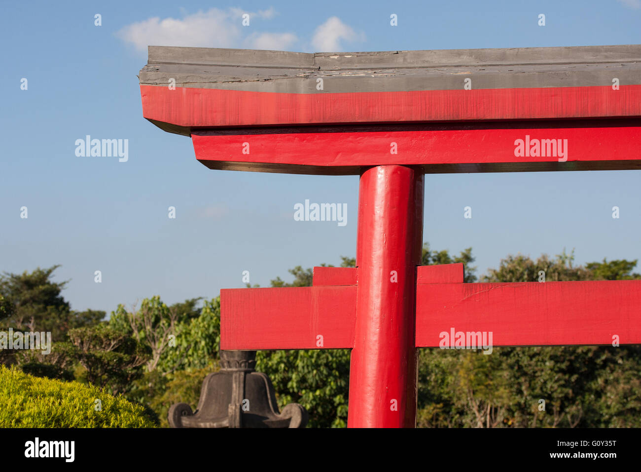 Red Japanese architecture with trees sky and clouds behind Stock Photo