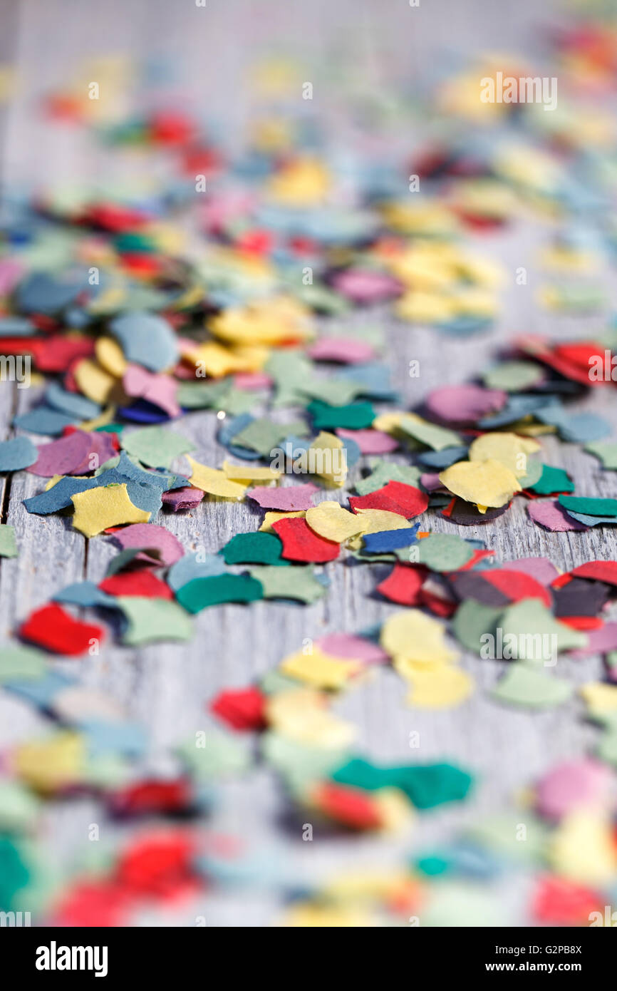 Bright multicolored Paper Confetti on Table in various shapes Stock Photo