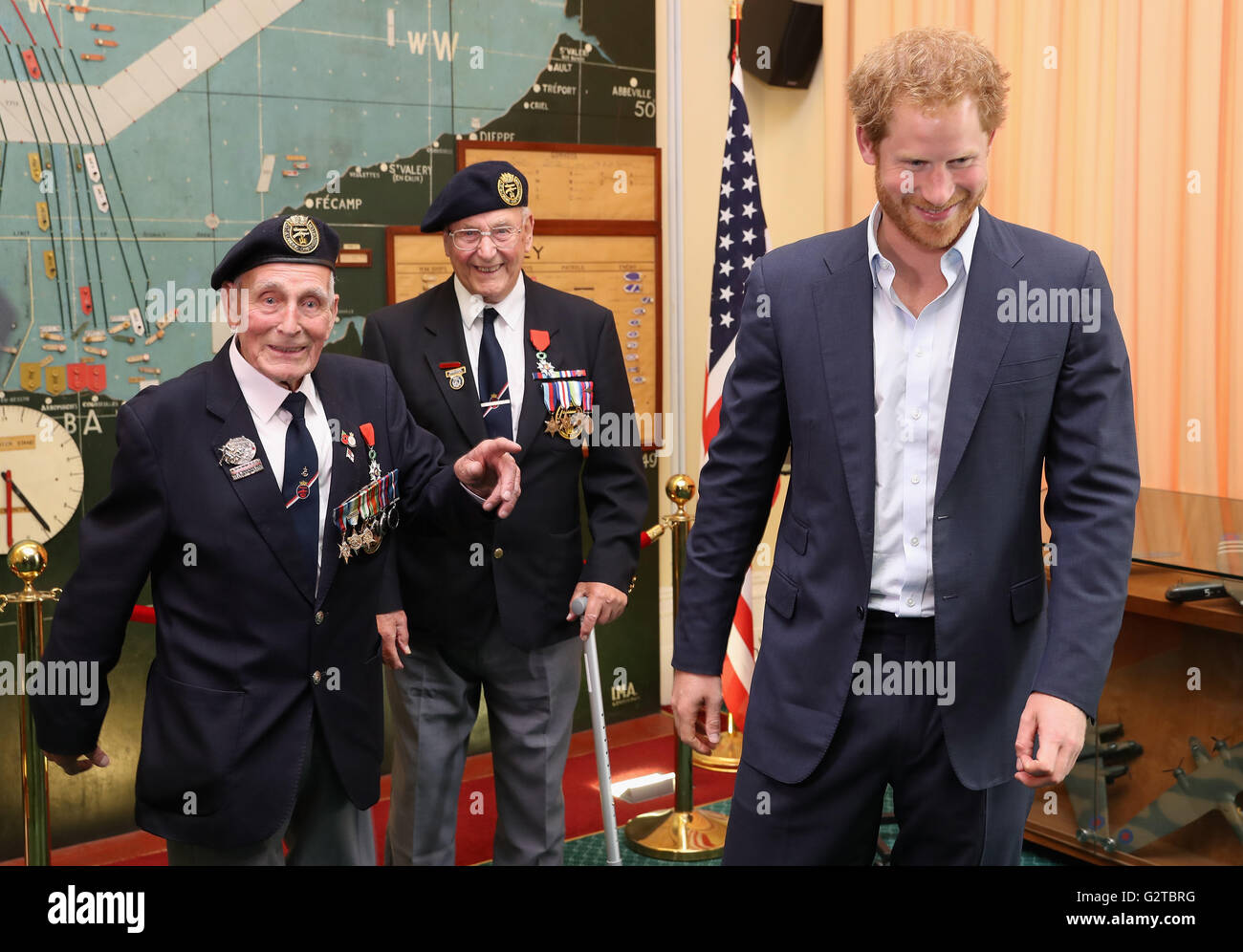 Prince Harry meets veterans John Dennett (left) and Frank Diffell (centre) in the Map Room during a reception with veterans who took part in the D-Day landings in 1944, at Southwick House, near Portsmouth, the headquarters where the Allied commanders planned the Normandy invasion. Stock Photo