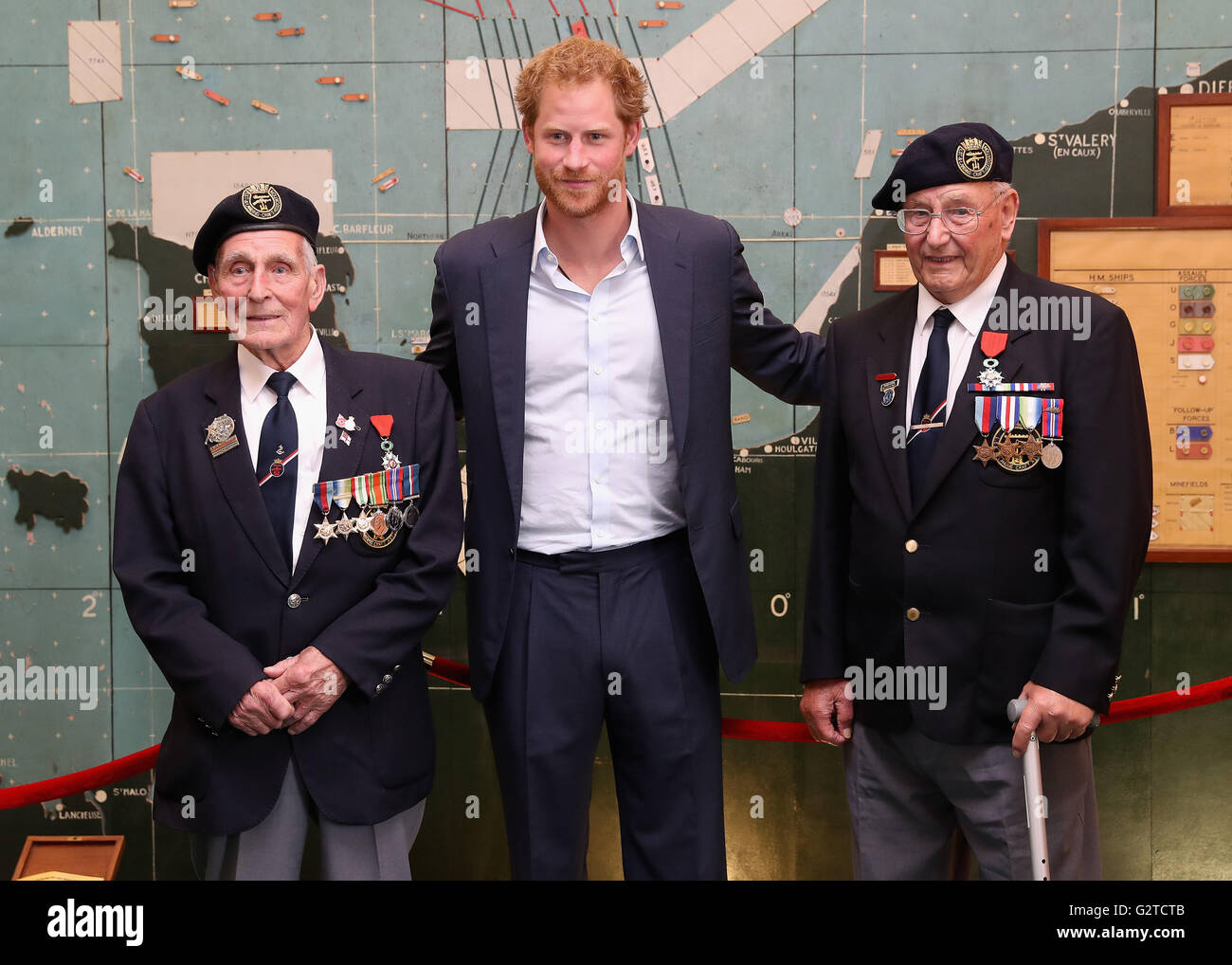 Prince Harry meets veterans John Dennett (left) and Frank Diffell (right) in the Map Room during a reception with veterans who took part in the D-Day landings in 1944, at Southwick House, near Portsmouth, the headquarters where the Allied commanders planned the Normandy invasion. Stock Photo