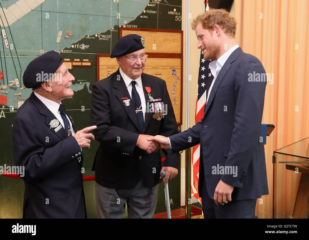 Prince Harry meets veterans John Dennett (left) and Frank Diffell (centre) in the Map Room during a reception with veterans who took part in the D-Day landings in 1944, at Southwick House, near Portsmouth, the headquarters where the Allied commanders planned the Normandy invasion. Stock Photo