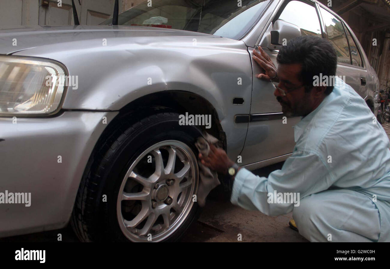 A poor man washing car to earn his livelihood for support of his family, at KCCI parking in Karachi on Friday, June 03, 2016. On Friday, Finance Minister Ishaq Dar presented budgetary proposals for financial year 2016-17 before the National Assembly which doesn't shows any relief for middle and lower class persons. Stock Photo