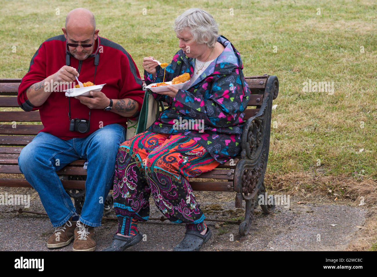 Bournemouth, Dorset, UK 3 June 2016. UK weather:  visitors enjoy themselves at Bournemouth despite overcast and cooler weather - couple sitting on bench eating takeaway meals in polystyrene trays Stock Photo