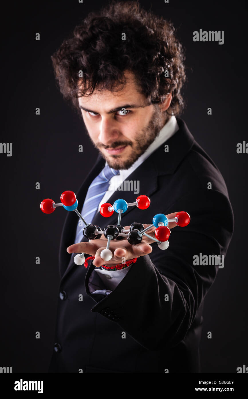 a businessman wearing a suit and a tie holding a trinitrotoluene tnt molecular model Stock Photo