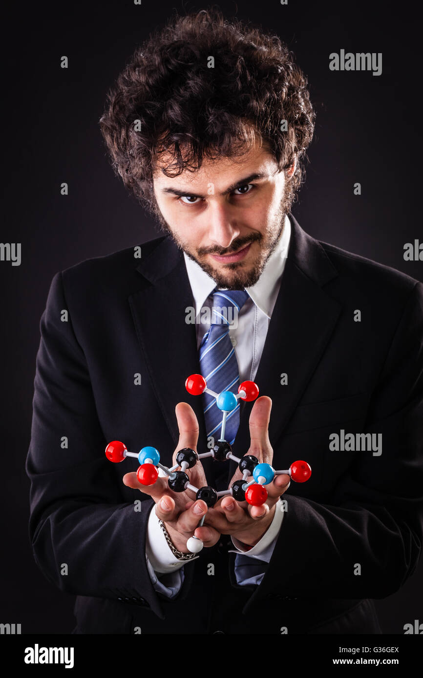 a businessman wearing a suit and a tie holding a trinitrotoluene tnt molecular model Stock Photo