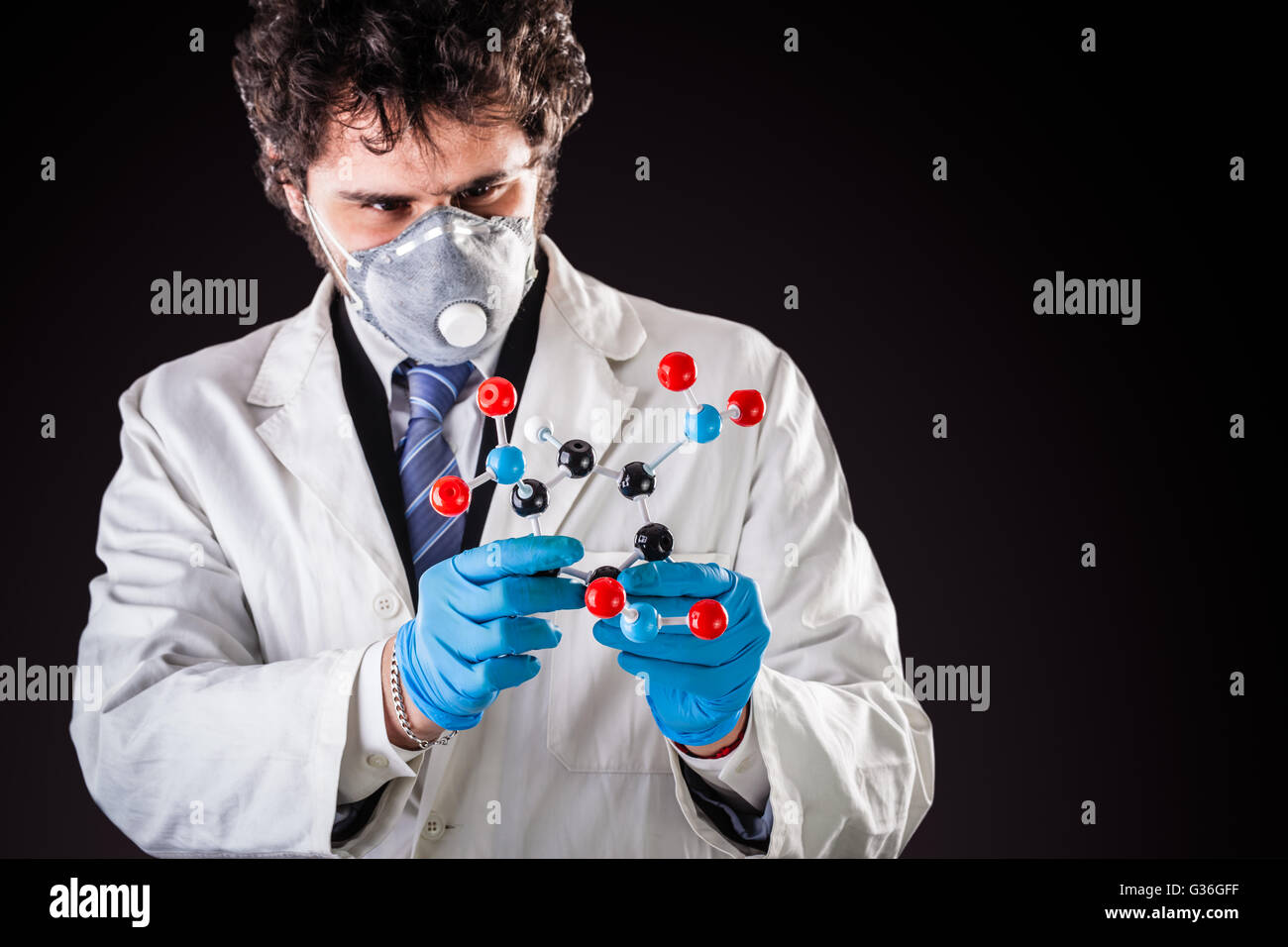 a doctor or researcher with a white lab coat holding a trinitrotoluene tnt molecular model Stock Photo