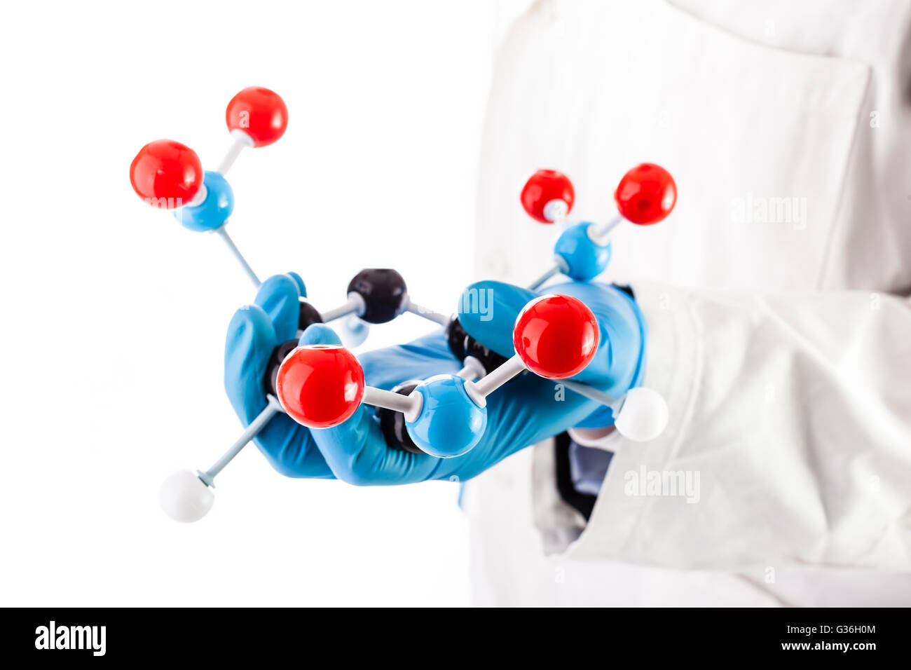 a doctor or researcher with a white lab coat holding a trinitrotoluene tnt molecular model isolated over white Stock Photo