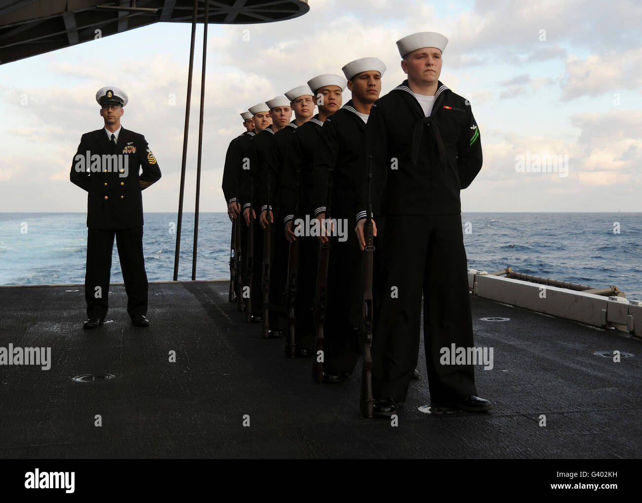 The honor guard stands at parade rest during a burial at sea. Stock Photo