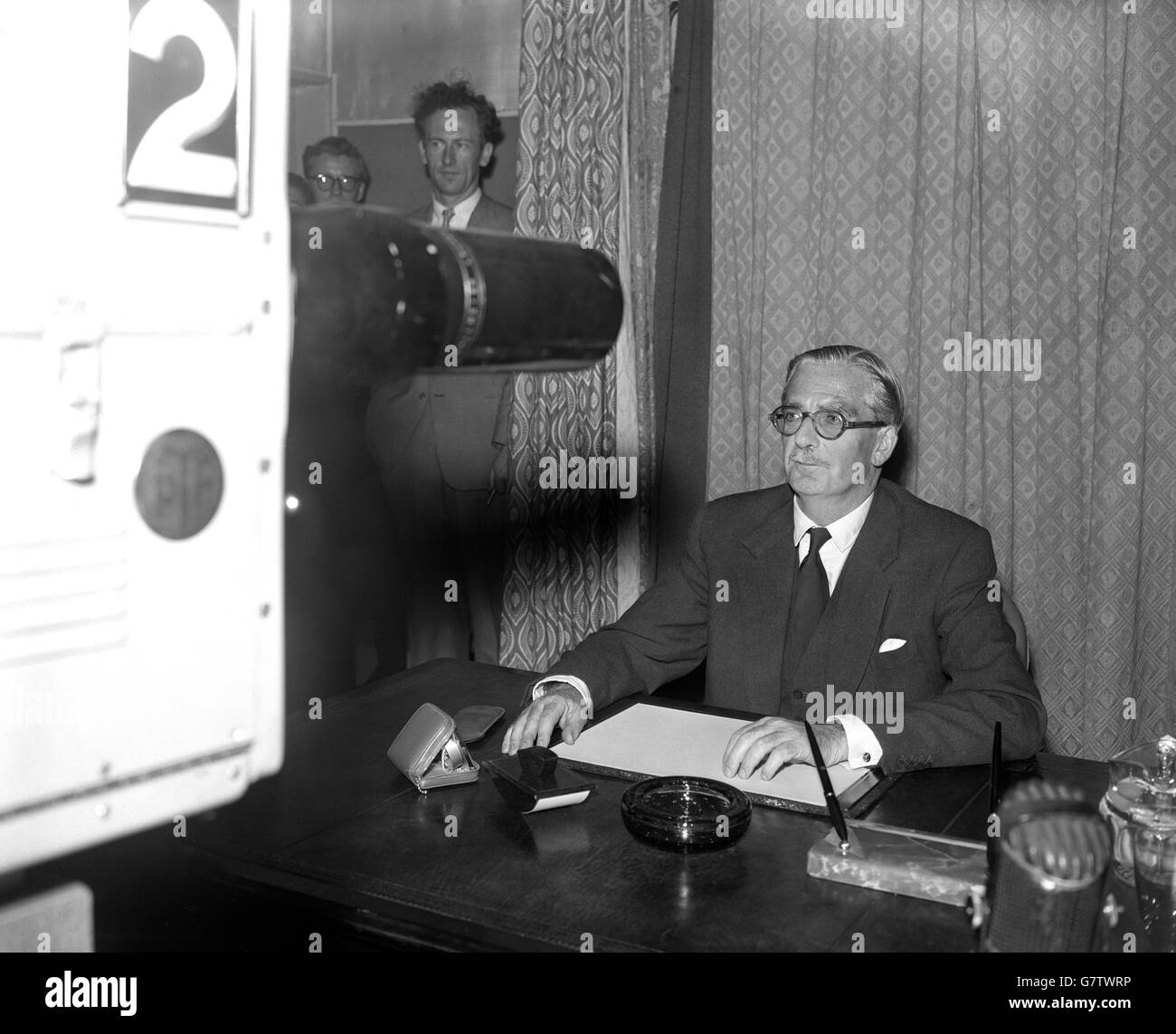 Sir Anthony Eden, Prime Minister, pictured before the televised camera in a BBC studio at Lime Grove, London, when he spoke to the nation for 14 minutes on the Suez Canal Crisis. 'If Colonel Nasser's action were to succeed,' he said, 'each one of us would be at the mercy of one man for the supplies upon which we live. We could never accept that.'. Sir Anthony told his listeners that 19 nations had already accepted the invitation to the conference on the Suez Canal. There had been no refusals. The Prime Minister was seen seated at a desk by viewers of both BBC and Independent television. Stock Photo