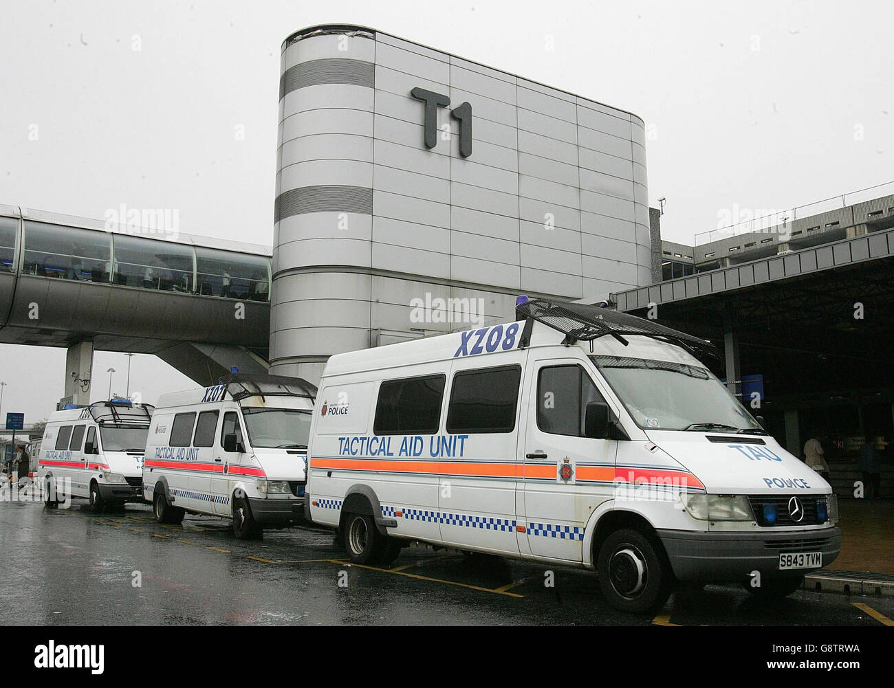 Police vans sit outside Terminal 1 of Manchester Airport, Friday September 23, 2005, where a man was arrested under the Terrorism Act after he was seen acting suspiciously near aircraft at the airport. Police used a Taser gun to pacify the suspect during a struggle on the apron near Terminal 2. Bomb disposal experts were called to examine a suspect package at the scene after the arrest. See PA Story POLICE Airport. PRESS ASSOCIATION Photo. Photo credit should read: Martin Rickett/PA Stock Photo