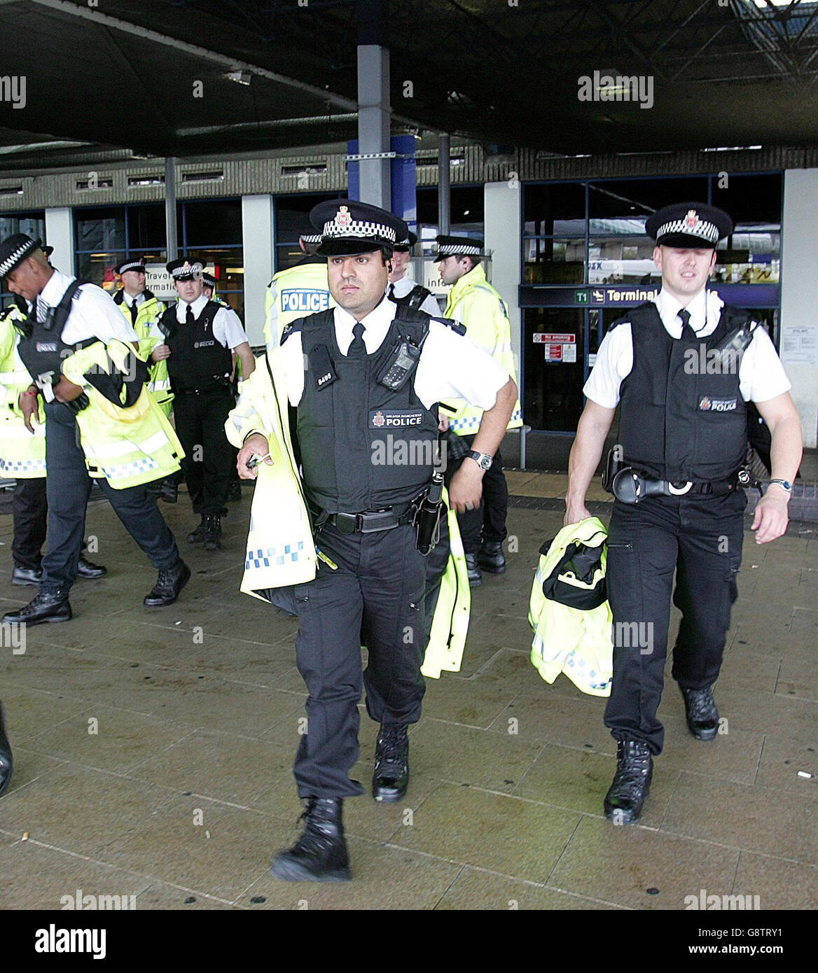 Police stand outside Terminal 1 of Manchester Airport, Friday September 23, 2005, where a man was arrested under the Terrorism Act after he was seen acting suspiciously near aircraft at the airport. Police used a Taser gun to pacify the suspect during a struggle on the apron near Terminal 2. Bomb disposal experts were called to examine a suspect package at the scene after the arrest. See PA Story POLICE Airport. PRESS ASSOCIATION Photo. Photo credit should read: Martin Rickett/PA Stock Photo