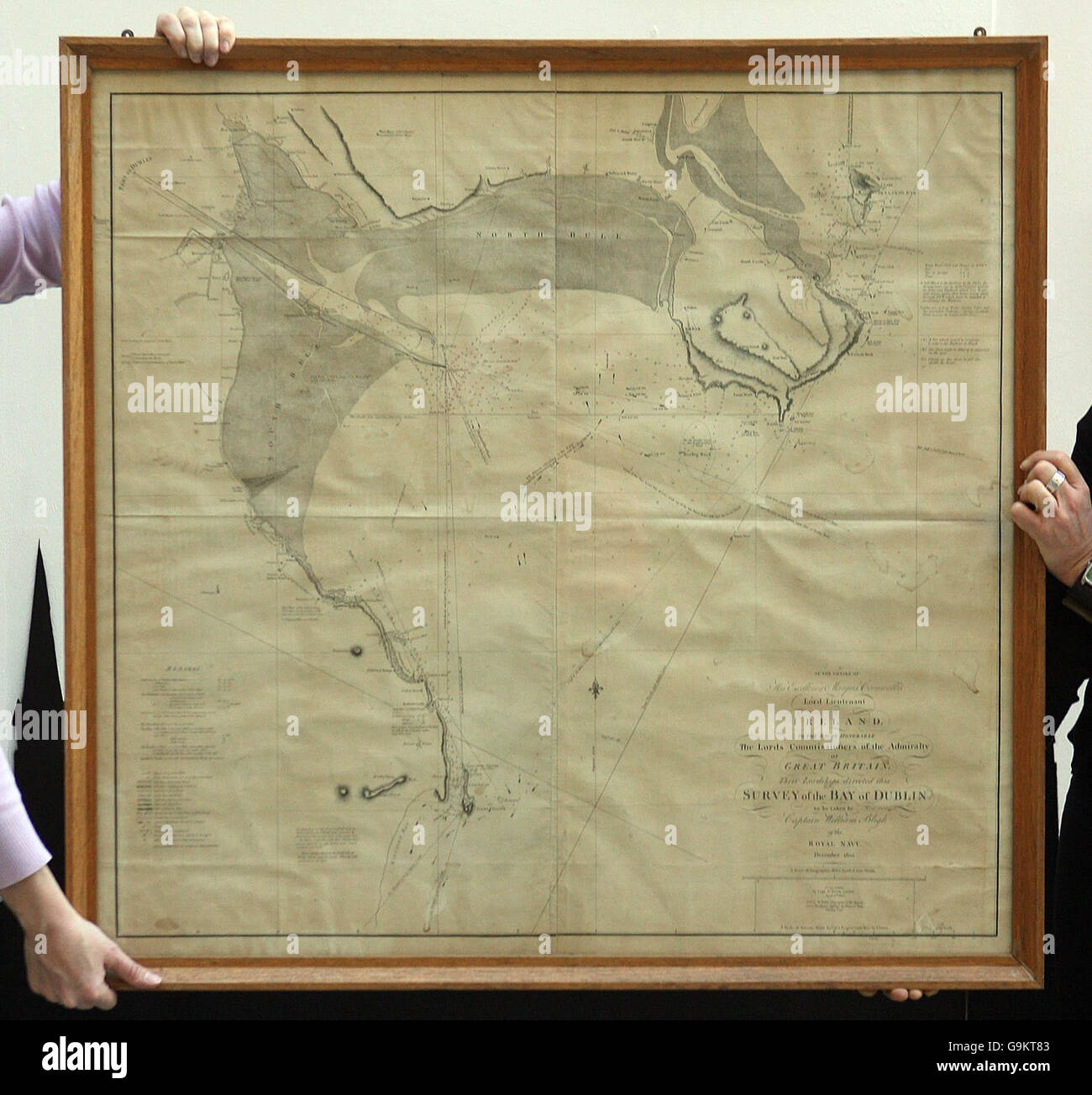 Curators prepare to hang an old map of Dublin Bay dating back from the 1800s drawn up by Captain William Bligh who was best known for the famous mutiny that occurred against his command aboard the Royal Naval Ship 'The Bounty'. Stock Photo