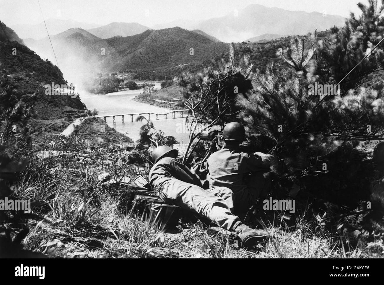 G.I.'s on the watch as Korea war tension increases As north Korean forces mass for a push across the Nektong River - the line defending American supply routes from Pusan to Taegu, provisional South Korean capital - American forces maintain a 24 - hour guard of possible invasion points. Pictured here: American soldiers manning a machine gun emplacement overlooking a bridge somewhere in Korea. Stock Photo