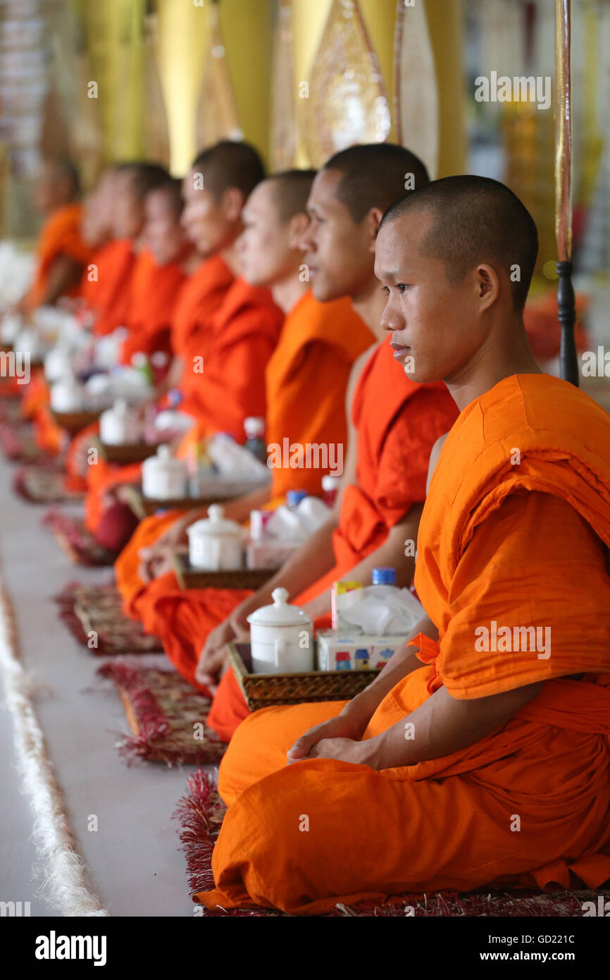 Seated Buddhist monks chanting and reading prayers at a ceremony, Wat Ong Teu Buddhist Temple, Vientiane, Laos, Indochina, Asia Stock Photo