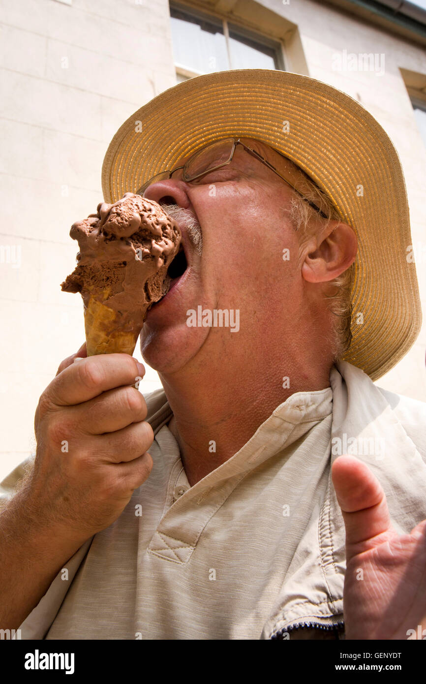 UK, England, Devon, Sidmouth, senior man eating large chocolate ice cream in wafer cone Stock Photo