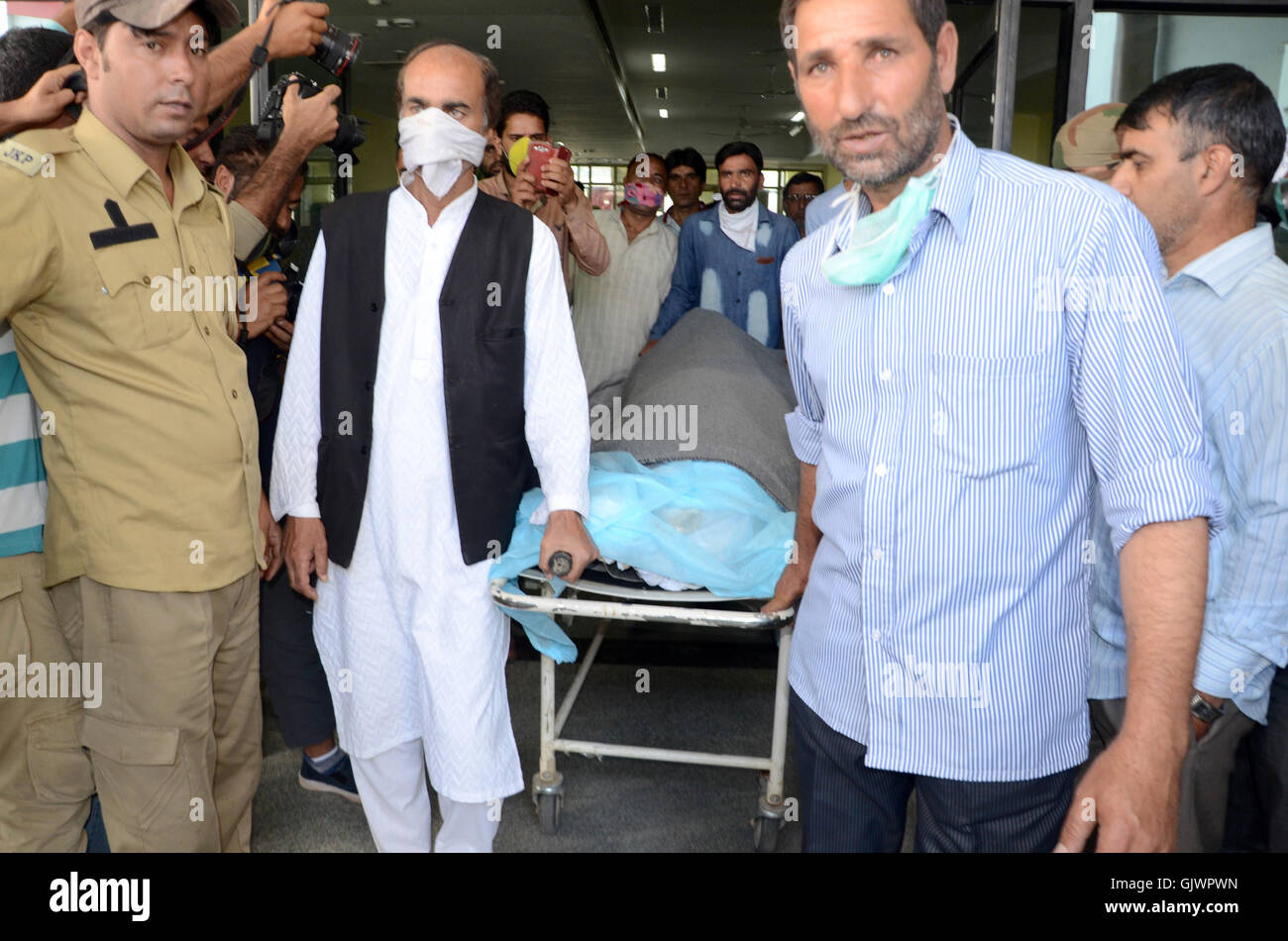 Srinagar, Kashmir. 18th August, 2016..Medical attendants carry the mortal remains of Kashmiri youth Shabir Ahmed at The Government Medical College after a post-mortem was conducted on court orders. Ahmed's body was earlier exhumed after his family sought the registration of a First Information Report(FIR) against a police officer who had allegedly shot him dead inside his house in the city's Tengpora area last month. Kashmir has been in the grip of almost daily anti-India protests and rolling curfews sparked by the killing on July 8 of a popular rebel leader, Burhan Wani, in a gunfi Stock Photo