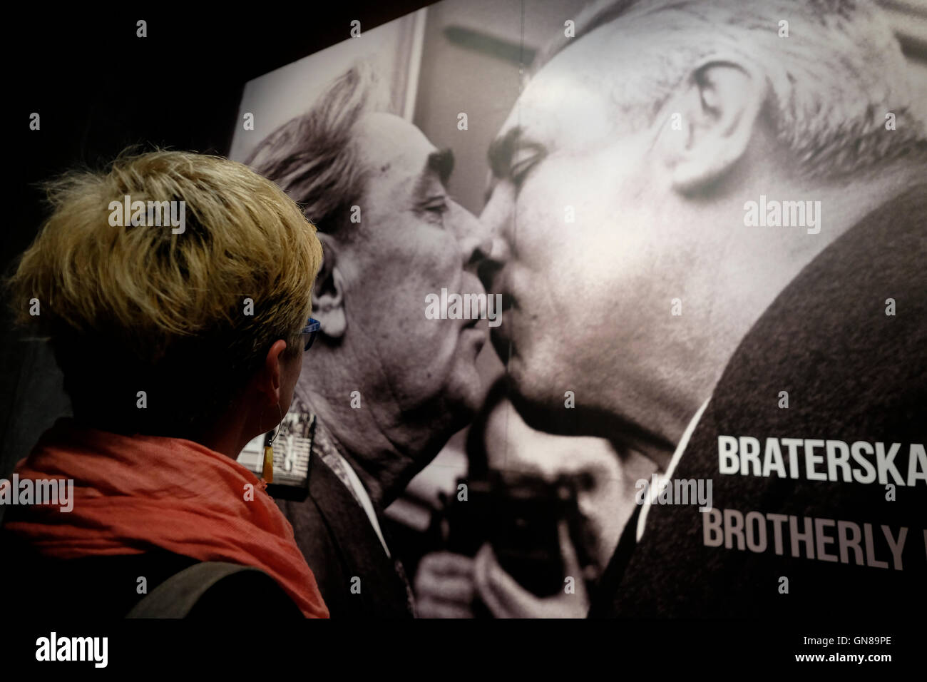 A visitor watching an old photo depicting Leonid Ilyich Brezhnev the General Secretary of the Central Committee (CC) of the Communist Party of the Soviet Union kissing a Polish leader inside the European Solidarity Center a museum and library devoted to the history of Solidarity, the Polish trade union and civil resistance movement, and other opposition movements of Communist Eastern Europe located in the city of Gdansk Northern Poland Stock Photo