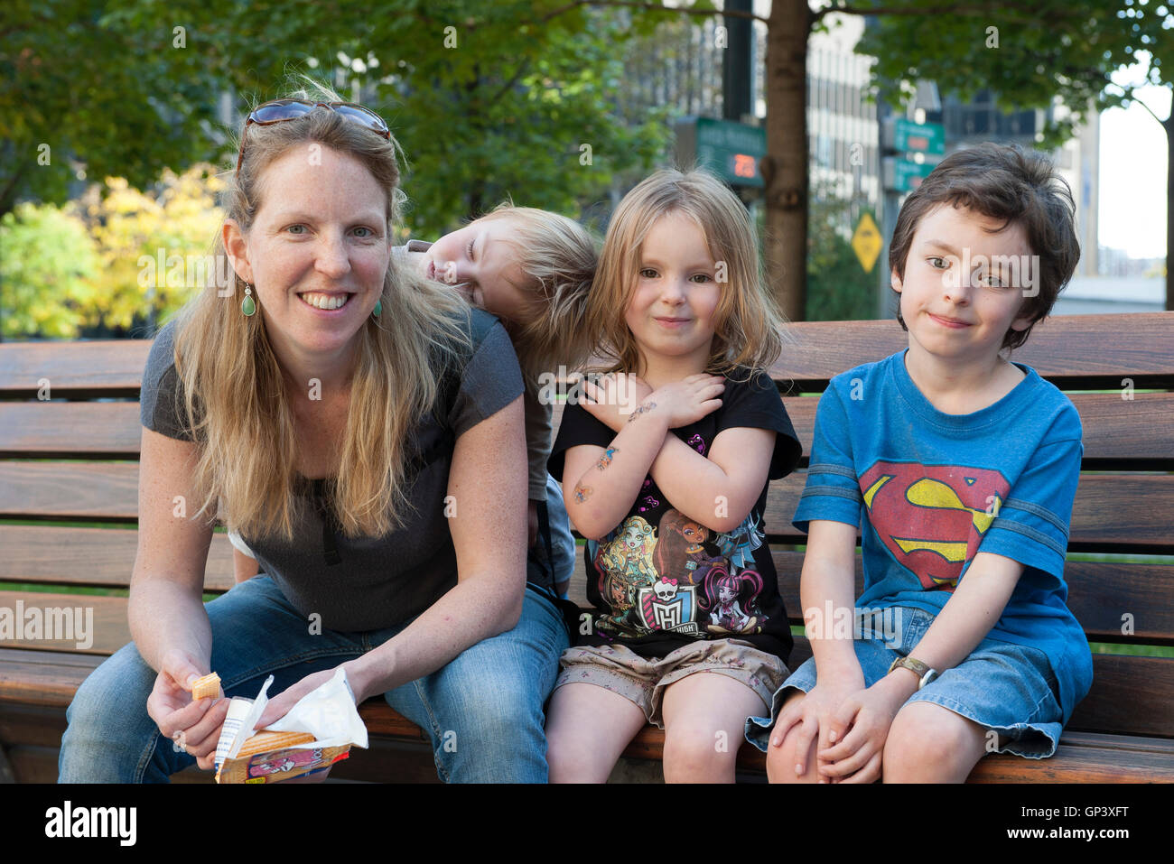 Family sitting together on bench, portrait Stock Photo