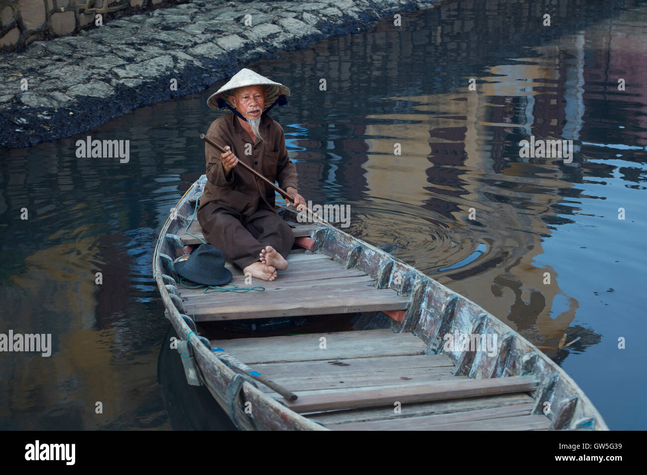 Elderly man with goatee and conical hat in boat, Hoi An (UNESCO World Heritage Site), Vietnam Stock Photo