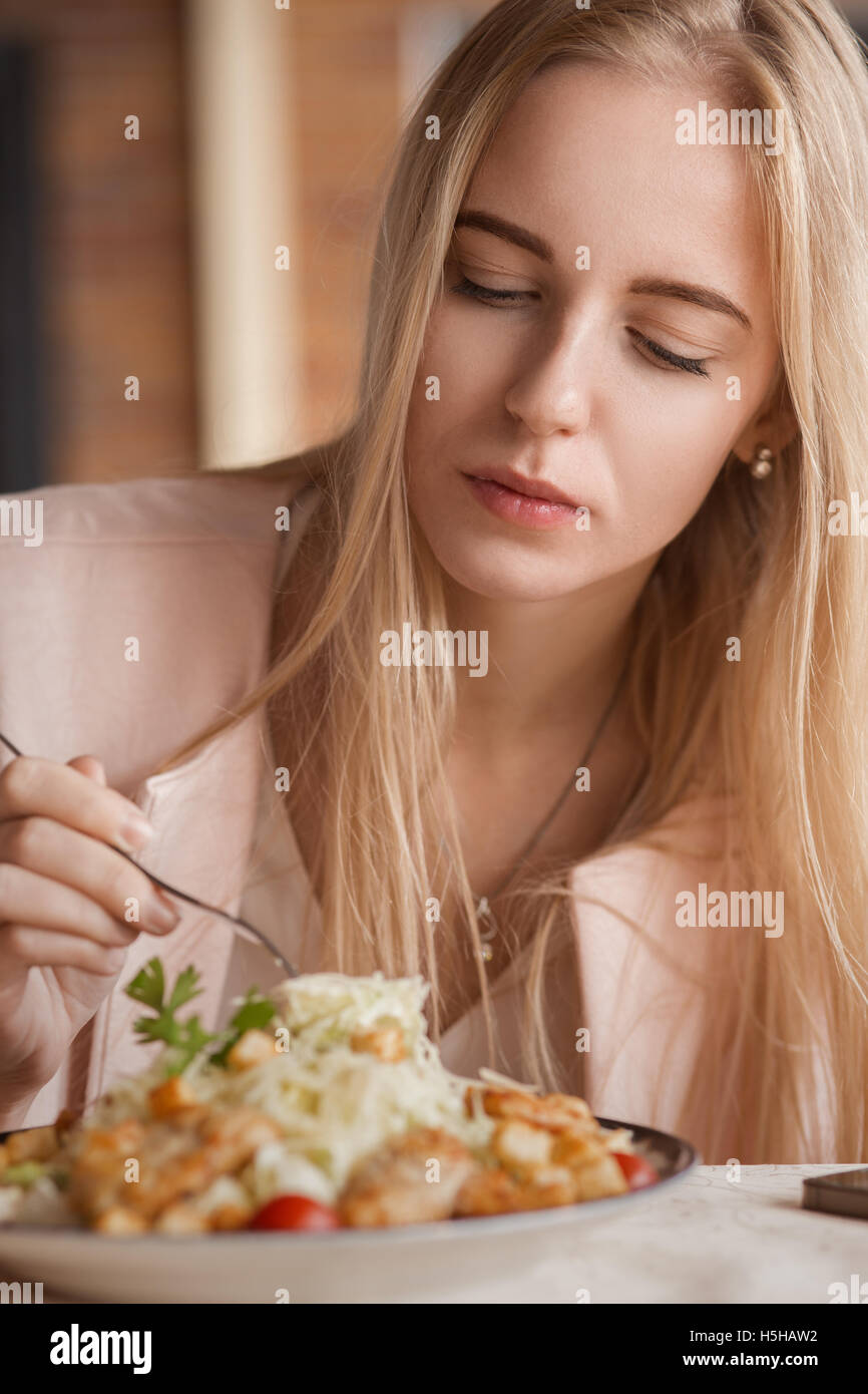 beautiful sad woman in cafe eating salad Stock Photo